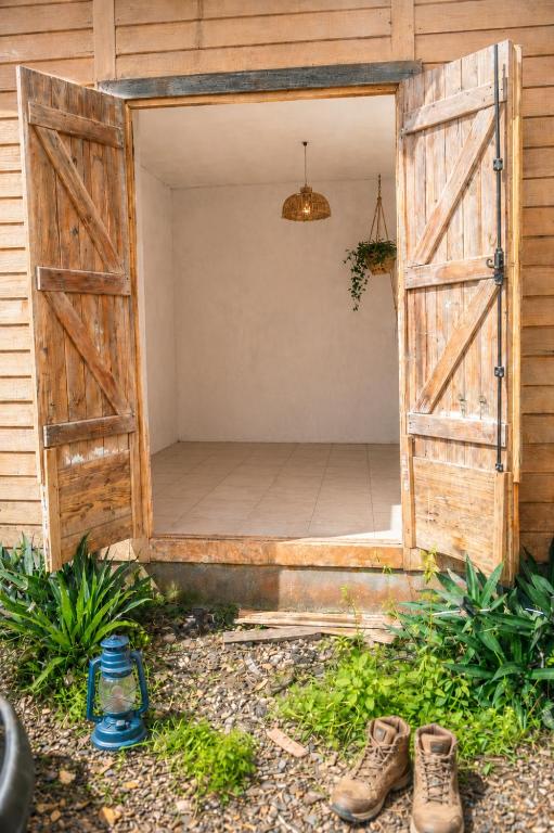 an open door to a patio with two pairs of shoes at Papaya Camping in Les Abymes