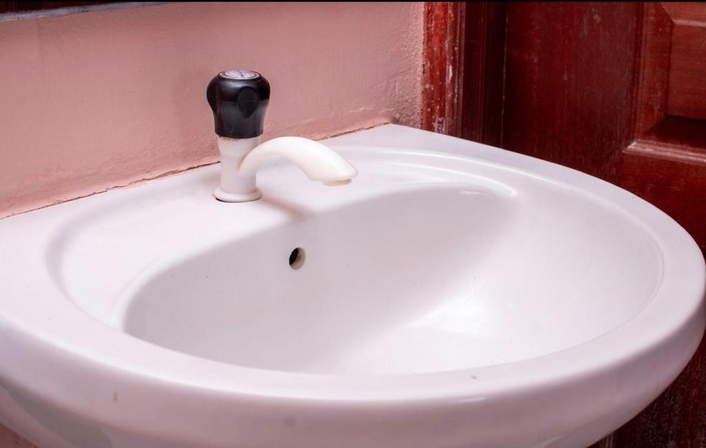 a white sink in a bathroom with aaucet at Dynasty homes in Bamburi
