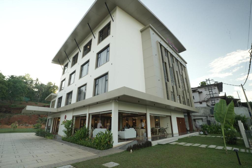 a large white building with a lot of windows at Mihas Hotels and Resorts in Malappuram