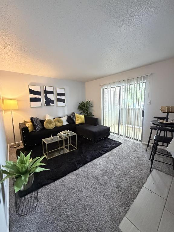 a living room with a black couch and a table at Cute 1bdr that sleep 4 minutes from ATT Stadium in Arlington