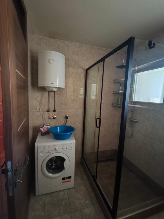 a bathroom with a washing machine and a sink at Stan Foca N in Foča