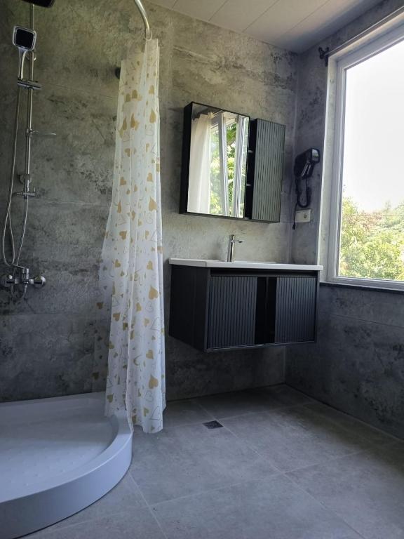 a bathroom with a shower curtain and a sink at Chakvi hotel in Chakvi