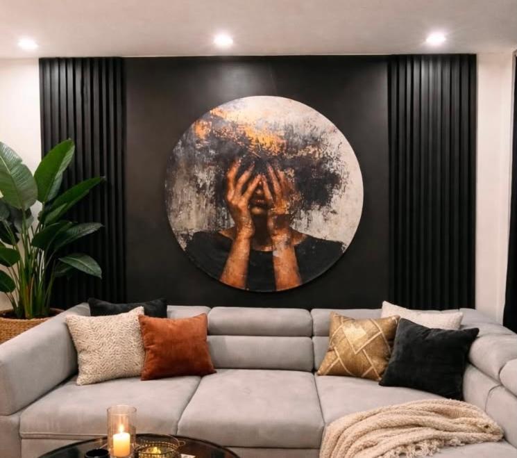 a living room with a couch and a painting on the wall at Kawalerka in Malbork