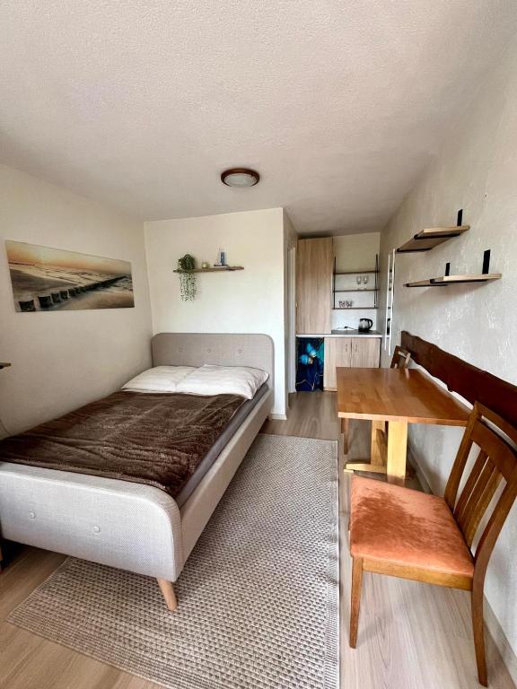 a bedroom with a bed and a wooden table at Pokoje na Okrężnej in Białogóra