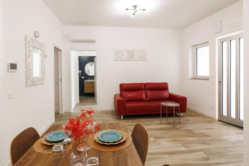 a living room with a red couch and a table at Corte EDN7 in Sannicandro di Bari