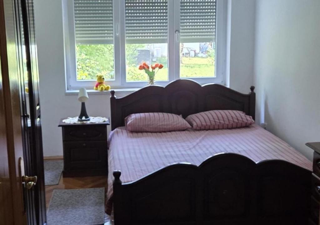 a bedroom with a bed and two windows at Una Mirage in Bihać
