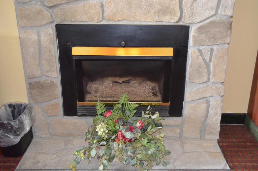 a stone fireplace with a christmas arrangement in it at Baymont by Wyndham Pigeon Forge near Island Drive in Pigeon Forge