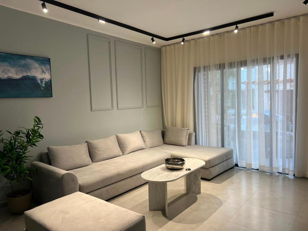 a living room with a couch and a table at Appartement Cassia Vue Piscine rénovée cette année in Cabo Negro