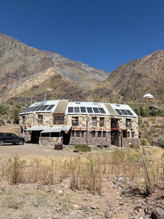 an old building with windows in the middle of a mountain at Refugio de Montaña Placaroja in San José de Maipo