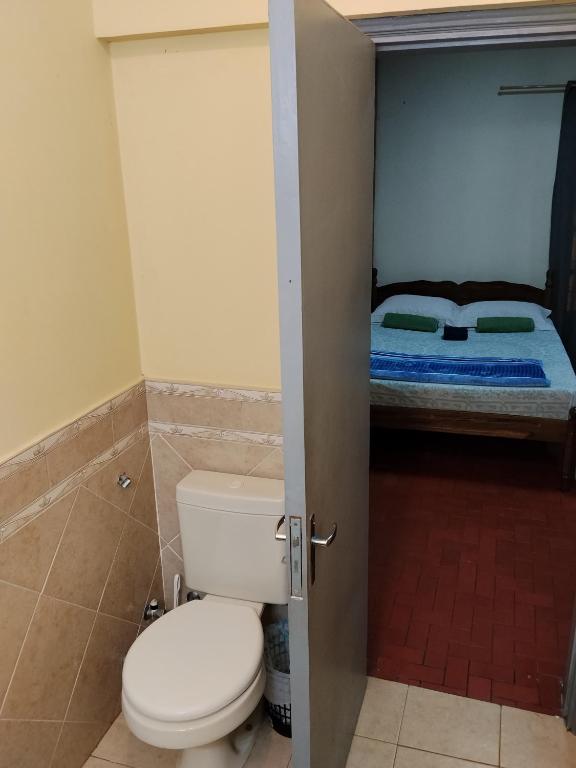 a bathroom with a toilet and a bed at La negrita in Villa Elisa