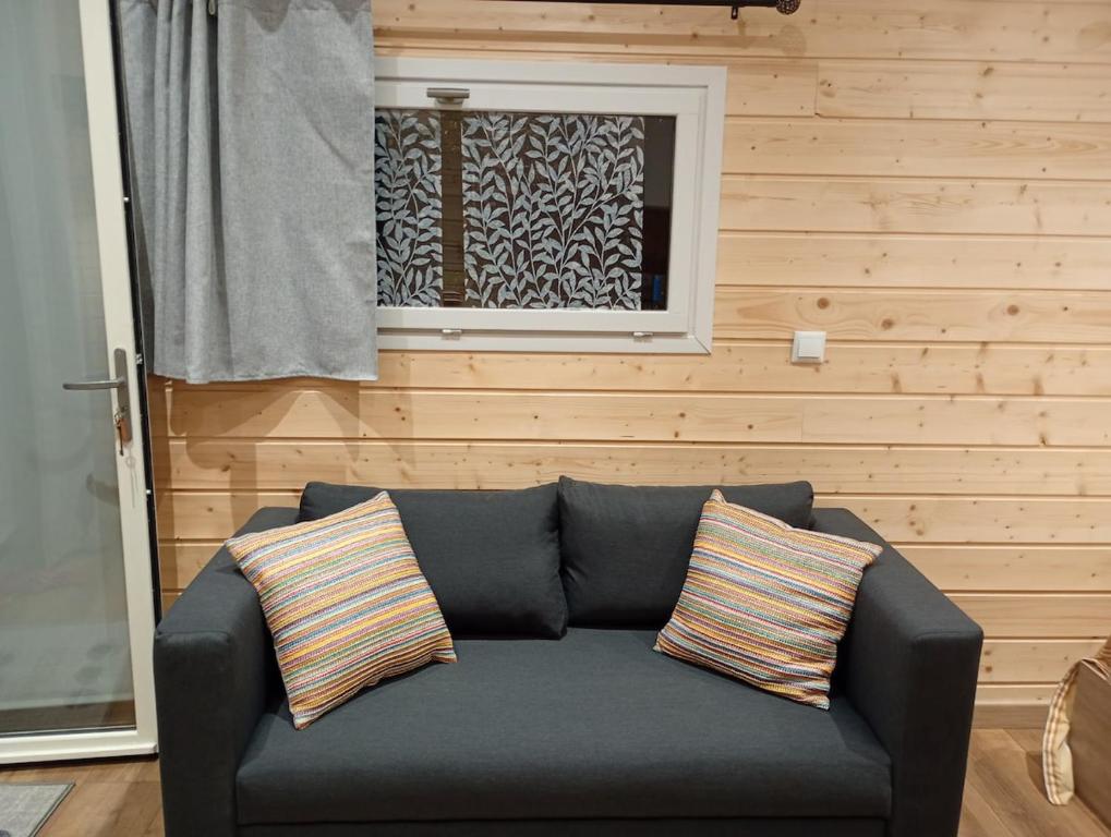 a blue couch in a room with a window at Studio chalet indépendant in Égletons