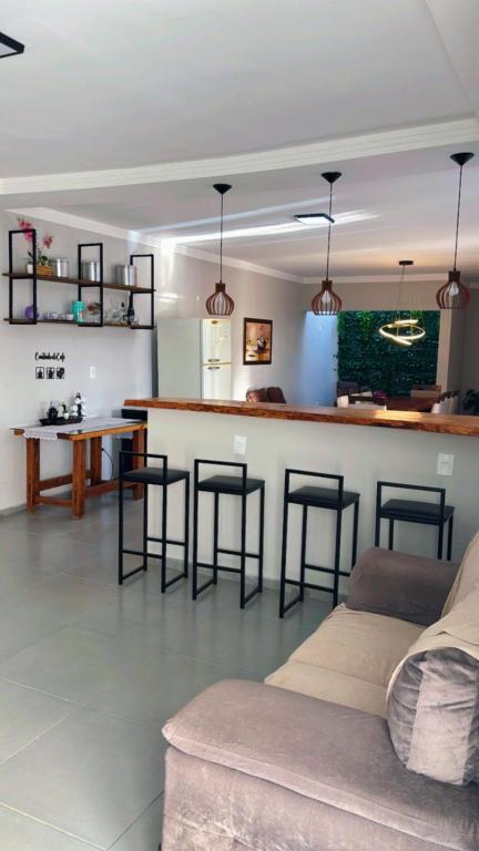 a living room with a bar and some stools at Chácara pôr do sol in Araçoiaba da Serra