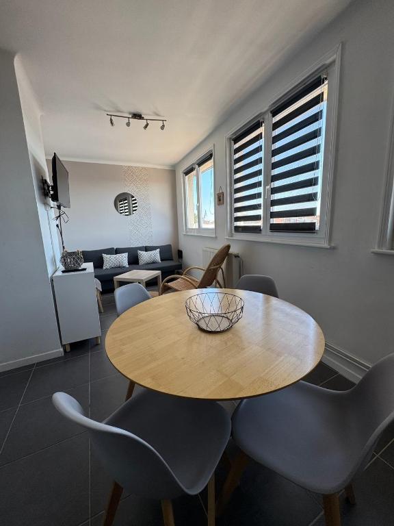 a dining room with a wooden table and chairs at Le logis de la Marina in Calais