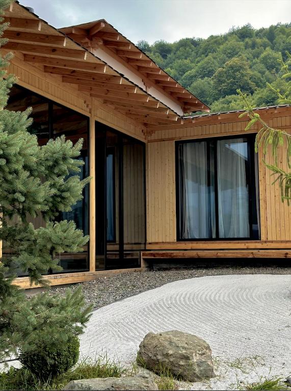 a wooden house with a rock in front of it at Amper Villa Dilijan in Dilijan