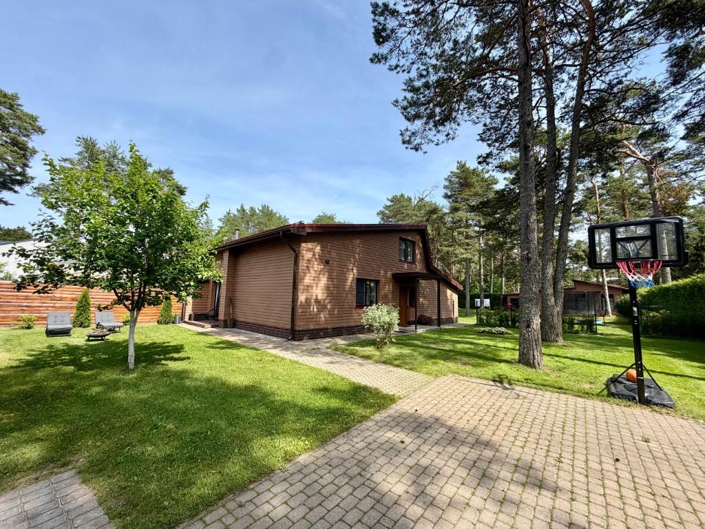 a house with a basketball hoop in a yard at Männimetsa in Narva-Jõesuu