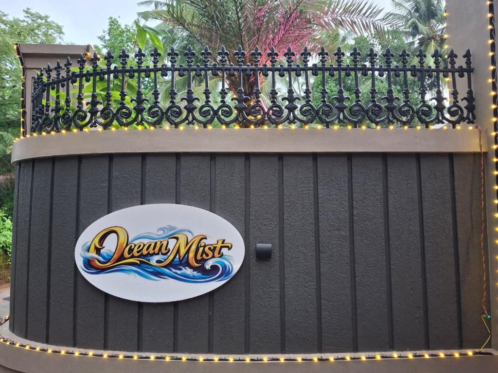 ein schwarzer Zaun mit einem Schild daran in der Unterkunft Ocean Mist in Kozhikode