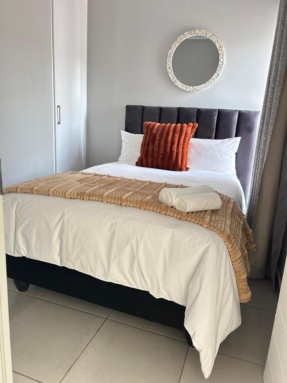 a bedroom with a large bed with a mirror on the wall at 166 Green valley in Boschrand