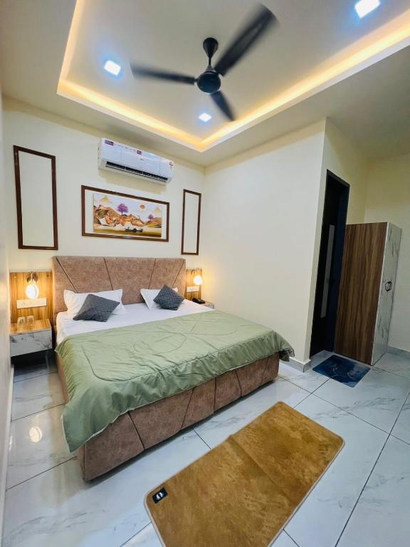 a bedroom with a bed and a ceiling fan at Norway Residency in Jagādhri