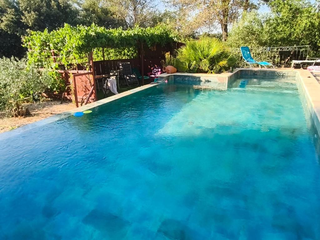 a large swimming pool with blue water at Etage privatif chez Corinne in Russan
