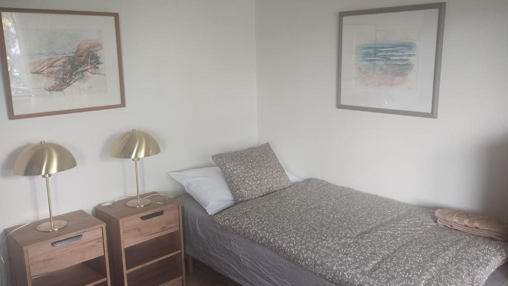 a bedroom with a bed and two night stands with lamps at Slussens Stay in Henån