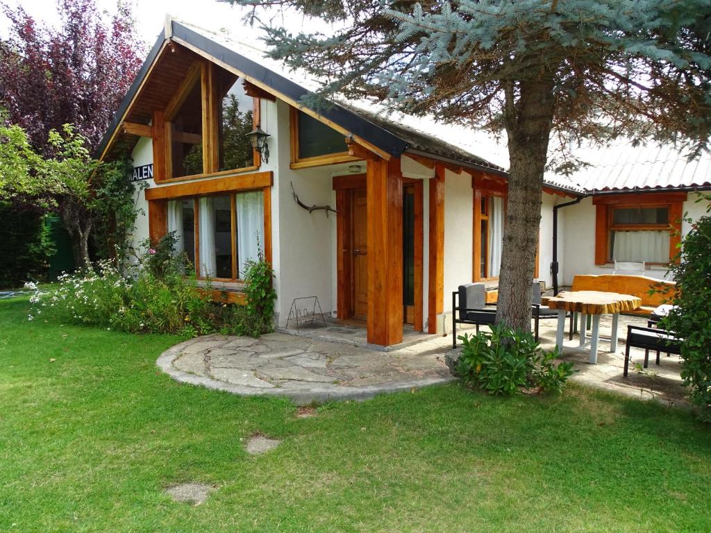 a white house with a table and a tree at Casa Malen Llao Llao in San Carlos de Bariloche