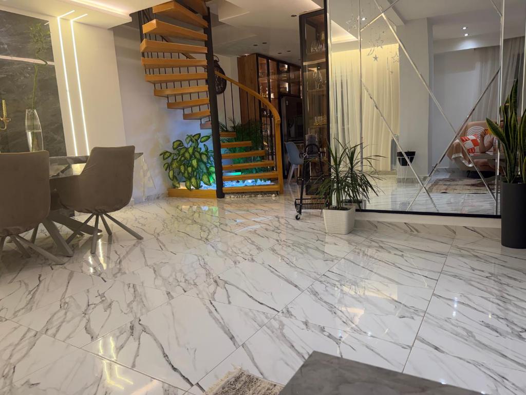 a lobby with a marble floor and a staircase at Duplex prestige in El Achour
