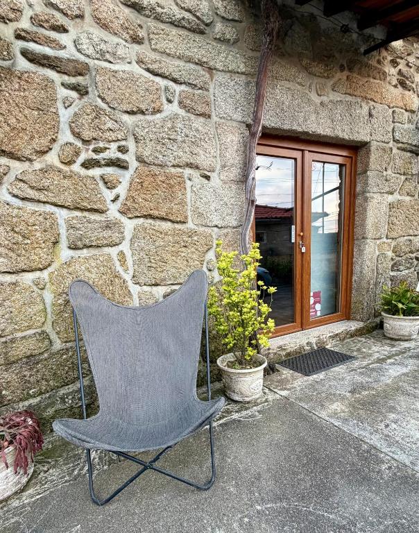 a chair sitting in front of a stone building at Casa da Adega in Sá