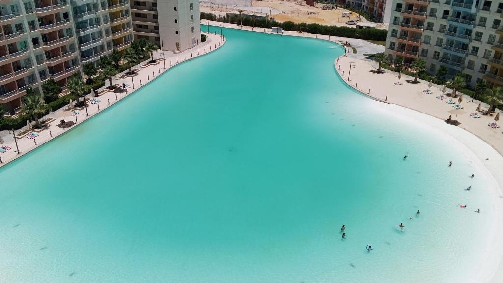 a large body of water with people on the beach at بورتوجولف portogolf in El Alamein