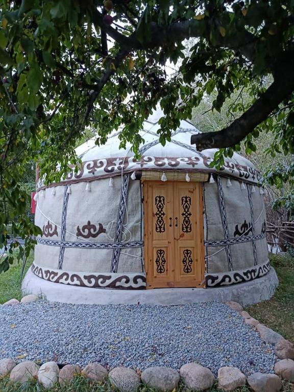 a dome house with a wooden door in the grass at 40 Rays Yurts in Bosteri