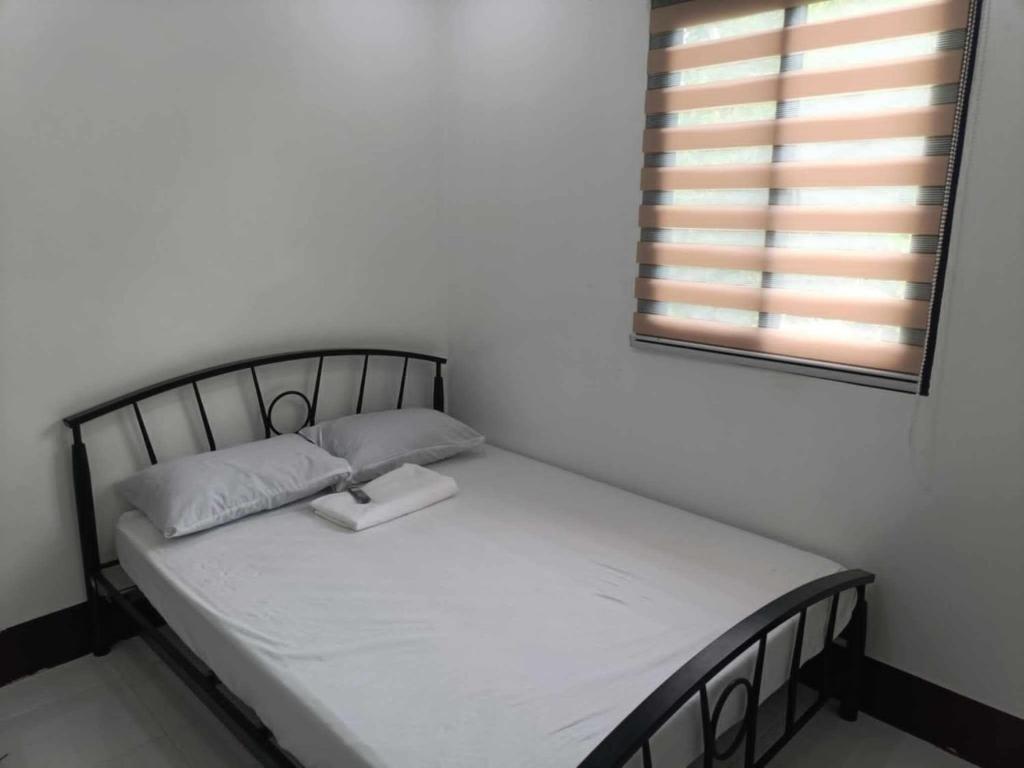 a small bed in a room with a window at ljp farm resort couple rooms in Tigaon