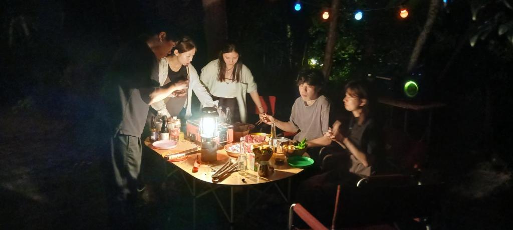 a group of people sitting around a table at night at Cafe&ResortInn VAIRGO in Hoki