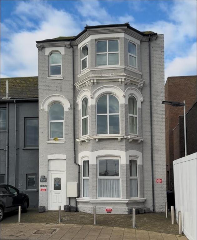 a large gray house with white windows on a street at STAYtastic in Lowestoft