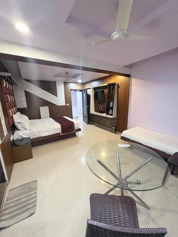 a room with a bed and a glass table in it at Hotel keshav in Ahmedabad