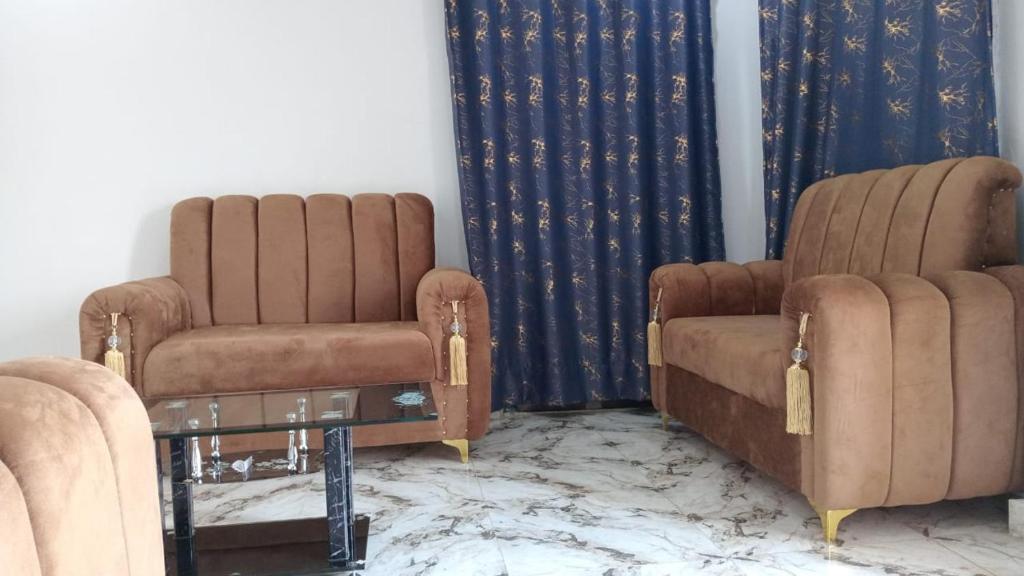 two chairs and a table in a room at BP Aura Stay in Akitan