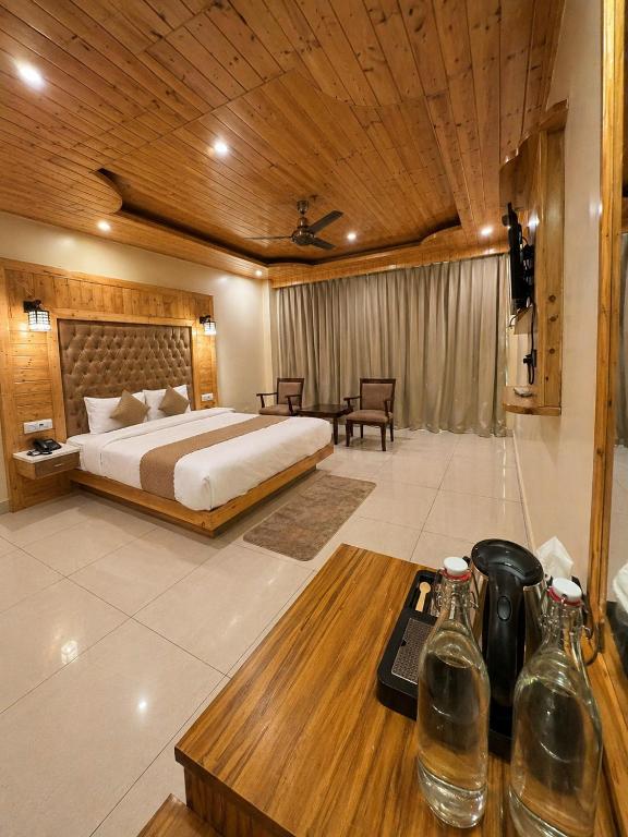 a bedroom with a bed and a table with bottles on it at The Tanwar Villas in Manāli