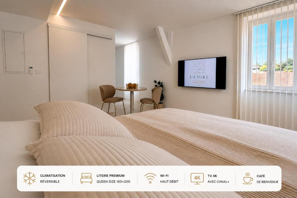 a bedroom with a bed and a table with chairs at Studio Premium Climatisé in Avallon