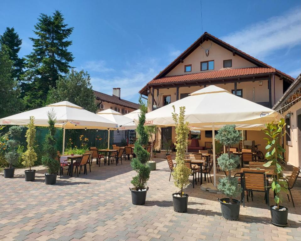 a patio with tables and chairs and umbrellas at Retro House in Pantelimon