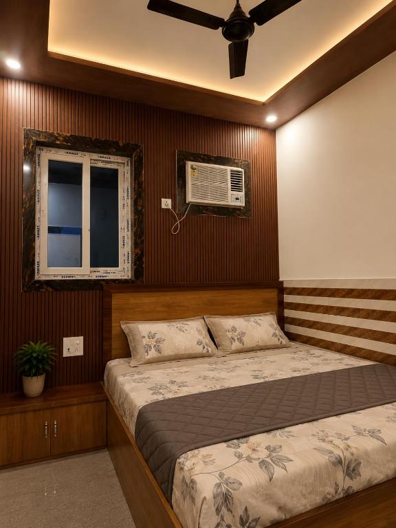 a bedroom with a bed and a window and a fan at Priya Dham in Govardhan