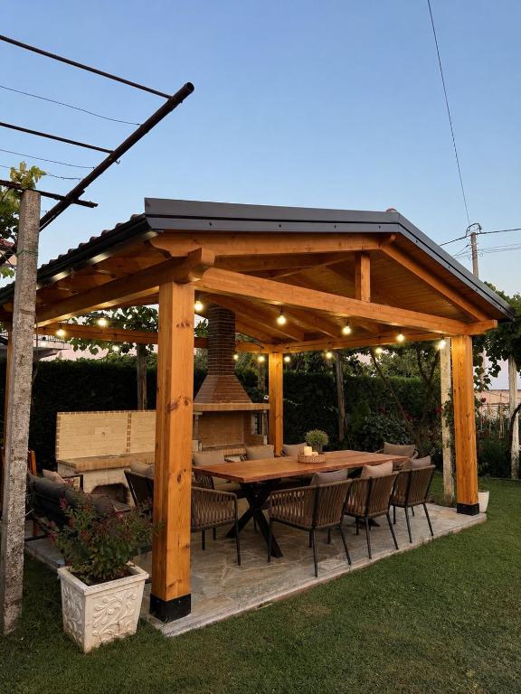 a wooden pavilion with a table and chairs at N'Gjaci Guest House in Tale