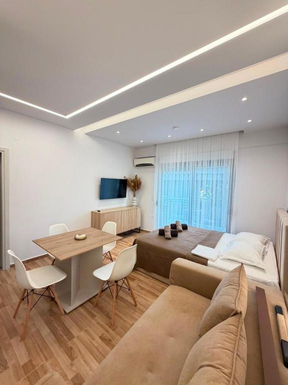 a bedroom with a large bed and a table and chairs at Vellora Central Suite in Xanthi