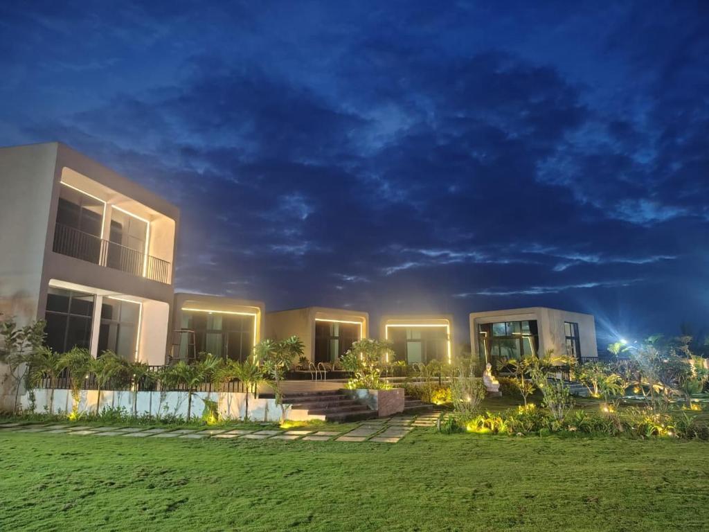 a house with a lawn in front of it at night at Achala Resorts in Maisaram