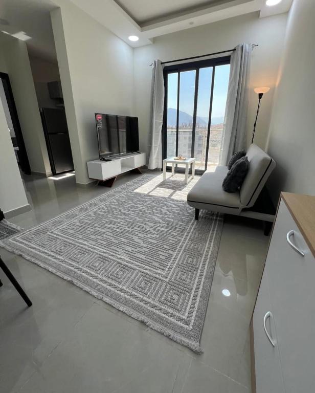 a living room with a couch and a large window at Bowsher 501 in Muscat