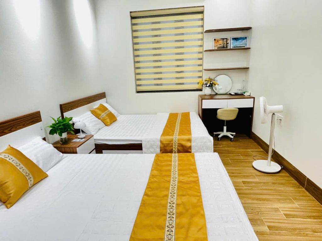 a bedroom with two beds and a desk in it at LanAnh homestay in Chung Cap