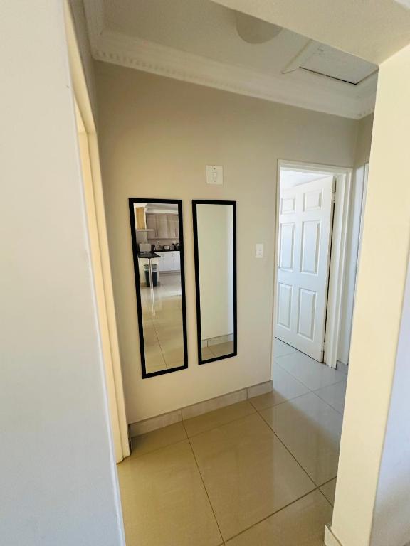 a hallway with two mirrors in a house at Kairos Home in Maseru