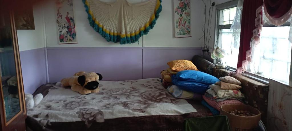 a room with a bed with a teddy bear on it at погружение в природу in Drăsliceni