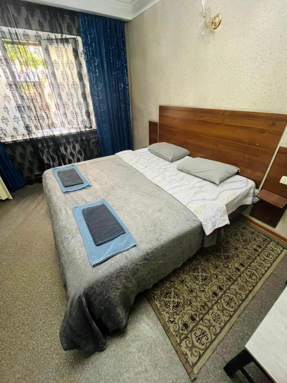a bedroom with a bed with two trays on it at Гостиница Роза in Almaty