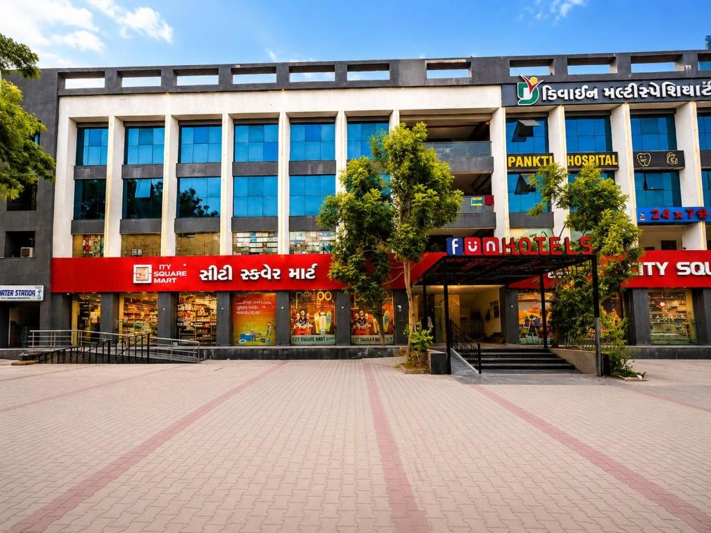 a building with a lot of shops in front of it at Fun Hotels Gandhinagar in Gandhinagar