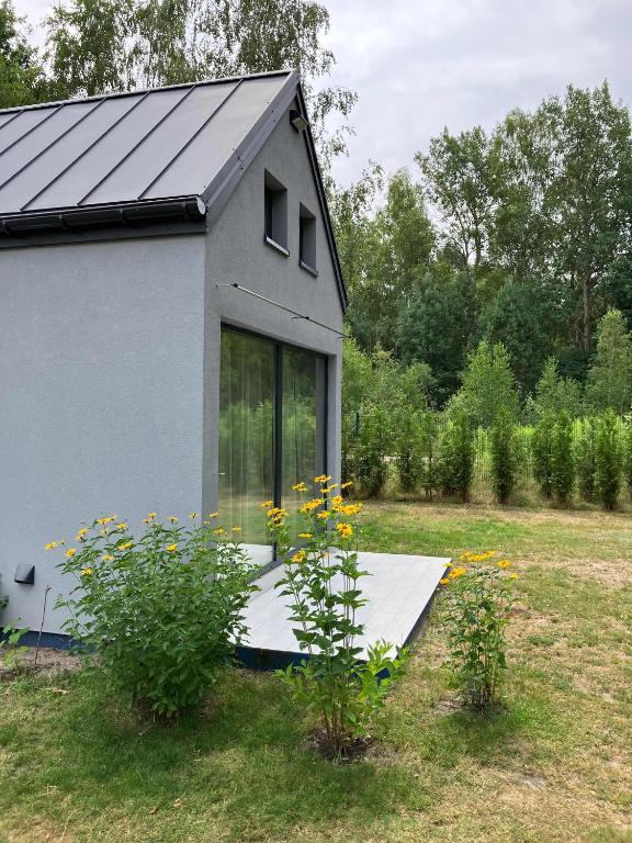 ein Haus mit einem Solarium auf einem Feld in der Unterkunft Wrzosowisko - Leśny Azyl dla Dwojga in Smolarnia