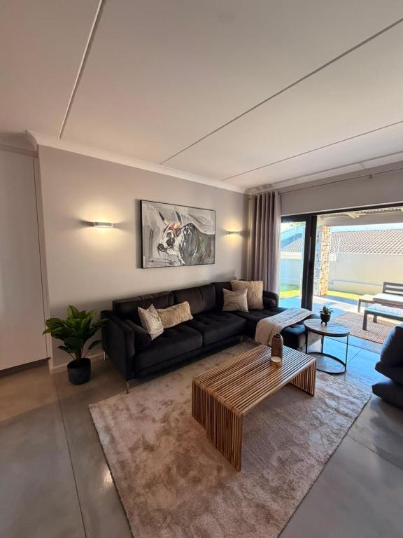 a living room with a couch and a coffee table at Cosy Langdown Getaway in Plettenberg Bay