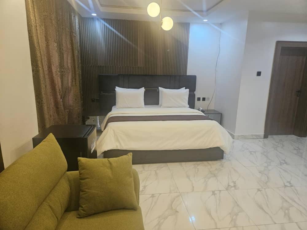 a bedroom with a large bed and a couch at Soilsmart Haven in Abuja